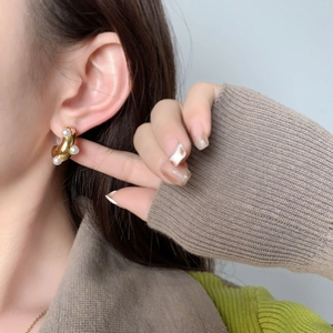 Orecchini a C irregolari placcati in oro con perle indossati da modella in foto lifestyle