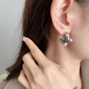 Eleganti orecchini a C in argento con perle bianche indossati per un look moderno