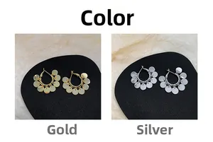 Detail view of bohemian hoop earrings with dangling gold and silver sequins