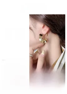 Detail of 24K gold plated hoop earrings with dangling metallic sequins and fringe effect