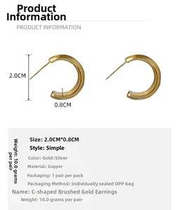 Detail showing dimensions and brushed matte gold texture of C-shaped copper earrings