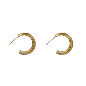 Minimalist C-shaped gold-plated hoop earrings with a brushed matte metallic texture