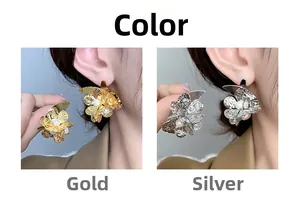 Detail of gold and silver flower stud earrings with hammered metal and center pearl