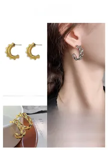 Vue détaillée des boucles d'oreilles en C avec texture chaîne torsadée dorée et argent