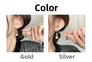 Detail view of pearl bell earrings in gold and silver finishes with layered metal design
