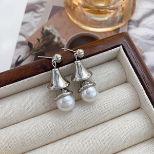 Elegant Chinese style gold plated pearl bell drop earrings on a vintage jewelry box edge