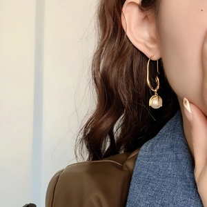 24K gold plated brass rope knot pearl drop earrings worn by a model in soft light