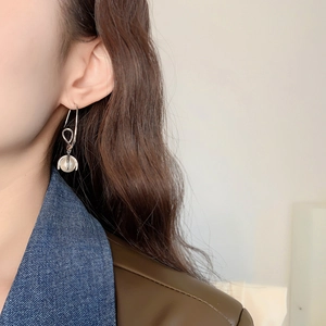 Elegant 24K gold plated brass knot drop earrings featuring a white pearl on a model