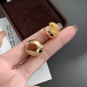 Close-up of gold-plated hoop earrings with half polished finish and half pavé zircon stones
