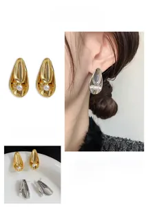 Detail of 24K gold plated brass leaf earrings with pearl, showing water drop texture