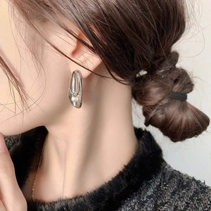 Elegant 24K gold plated leaf earrings with white pearls shown on a female model
