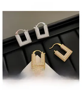 Macro detail of U-shaped earrings in gold and silver finish with full pave cubic zirconia