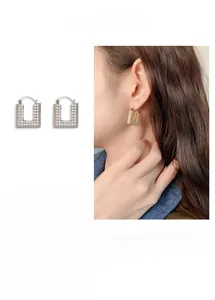 Detail view of U-shaped earrings with micro-set zircons in gold and silver plating