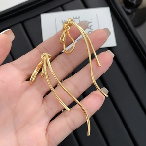 Detail von 18k vergoldeten Knoten-Ohrringen, die von Hand gehalten werden, Hochglanz-Finish
