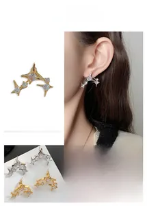 Macro detail of star-shaped earrings featuring layered design and sparkling cubic zirconia