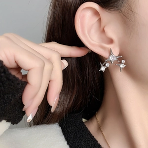 Elegant starburst zircon earrings in silver finish worn by a model in a close-up shot