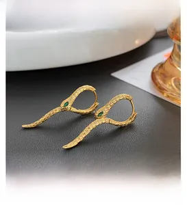 Macro di orecchini a serpente in oro 18K con gemme verdi e texture a scaglie fini