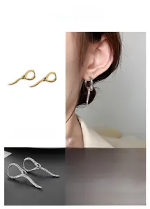 Dettaglio orecchini a cerchio serpente con gemme verdi e squame in oro e argento