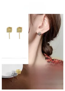 Détail des boucles d'oreilles cube avec gravure d'étoile en plaqué or et argent