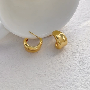 Polished gold-plated chunky hoop earrings in a minimalist eggplant-shaped metal design