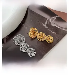 Detail of gold and silver hollow woven ball earrings showing spiral braided texture