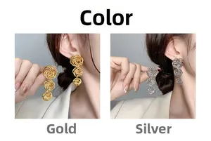 Close-up of tiered spiral hollow sphere earrings in gold and silver on a model