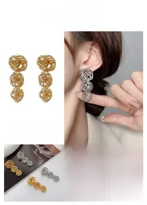 Close-up of three-tier gold and silver hollow spiral knot tassel earrings for women