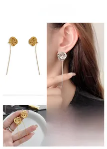 Macro view of 24K gold plated rose flower earrings with delicate long chain tassels