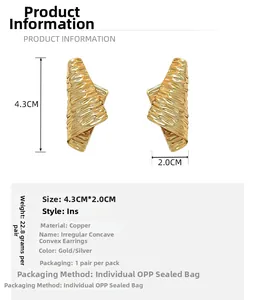Detail shot of irregular textured gold earrings with dimensions 4.3cm by 2.0cm