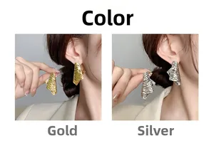 Detailed close-up of gold and silver irregular textured earrings with metallic finish