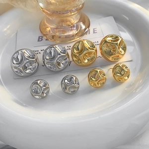 Détails de boucles d'oreilles boules martelées or et argent avec une texture irrégulière