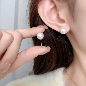 Gros plan de boucles d'oreilles perles rondes 8mm dorées pour un style vintage français