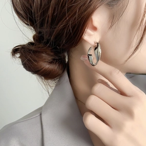 Minimalist silver irregular U-shaped geometric stud earrings on a fashion model