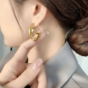 Minimalist irregular gold liquid style earrings with polished geometric texture on model