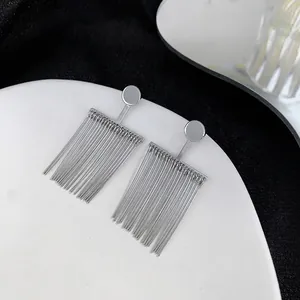 Detailed view of silver minimalist tassel earrings with vertical metal chains on a tray