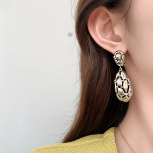 Modern vintage style hollow metal drop earrings with shiny silver finish and tassel design