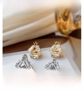 Detail of 18K gold plated triangle hoop earrings set with clear baguette crystals