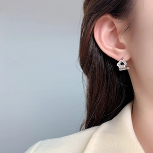 Close-up of minimalist triangle earring with inlaid rectangular cubic zirconia on ear