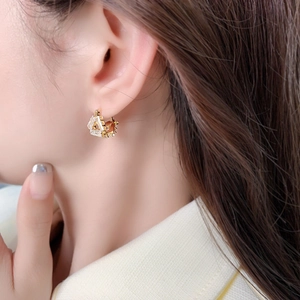 Elegant gold triangle huggie hoop earrings with baguette cut crystals worn by a model