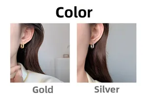 Elegant U-shaped gold and silver earrings with zircon pavé shown on model's ear