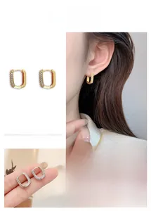 Detail of elegant U-shaped gold earrings with micro-pave cubic zirconia inlay