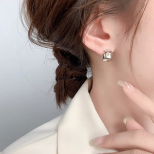 Minimalist silver geometric C-shape stud earrings with faceted origami metal texture