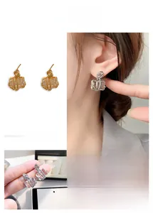 Détail de boucles d'oreilles en cristal rectangulaire avec fil doré torsadé de luxe