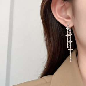 Elegant silver-plated clover cross fringe earrings with zircons shown on model