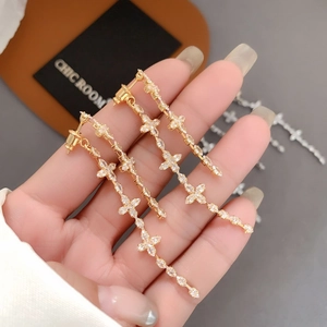Elegant gold clover cross tassel earrings with sparkling crystals for a chic look