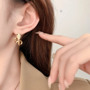 Elegant 18K gold plated snake-shaped stud earrings with sparkling pavé diamonds on a model