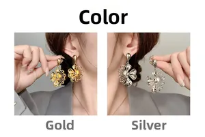 Detail of hollow petal drop earrings in gold and silver finish on model