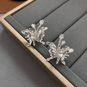 Detailed view of silver butterfly stud earrings with liquid metal design and zircons