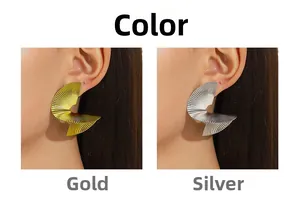 Detail view of 18k gold and silver spiral stud earrings with elegant pleated metal texture