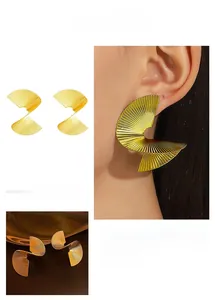 Detail of spiral fan-shaped earrings with gold plating and fine radial textures